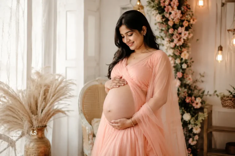 Beautiful Indian woman posing for an indoor maternity photoshoot.