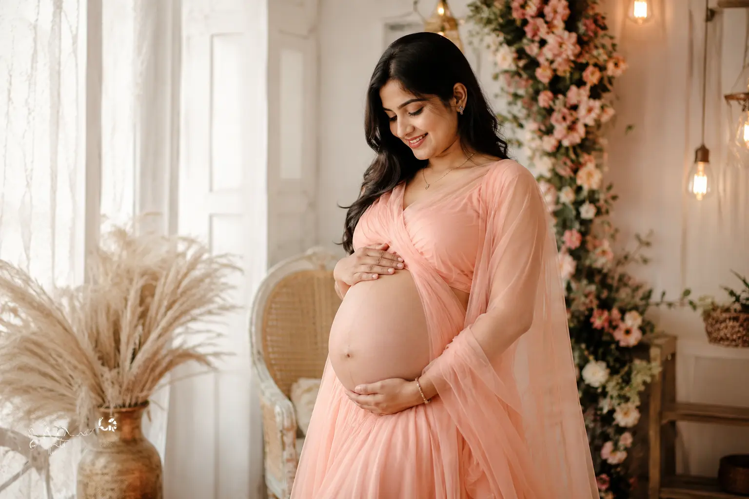 Beautiful Indian woman posing for an indoor maternity photoshoot.